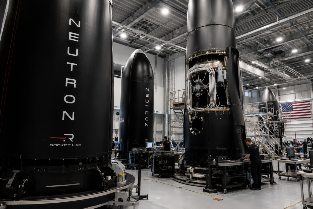 Rocket Lab stock has slowly formed a bullish pattern: time to buy? Rocket Lab engineers work around Neutron rocket hardware inside a large assembly facility.